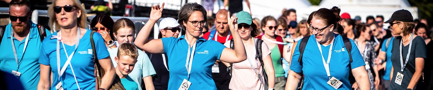 Eine Gruppe in tuerkisen Shirts jubelt der Kamera zu
