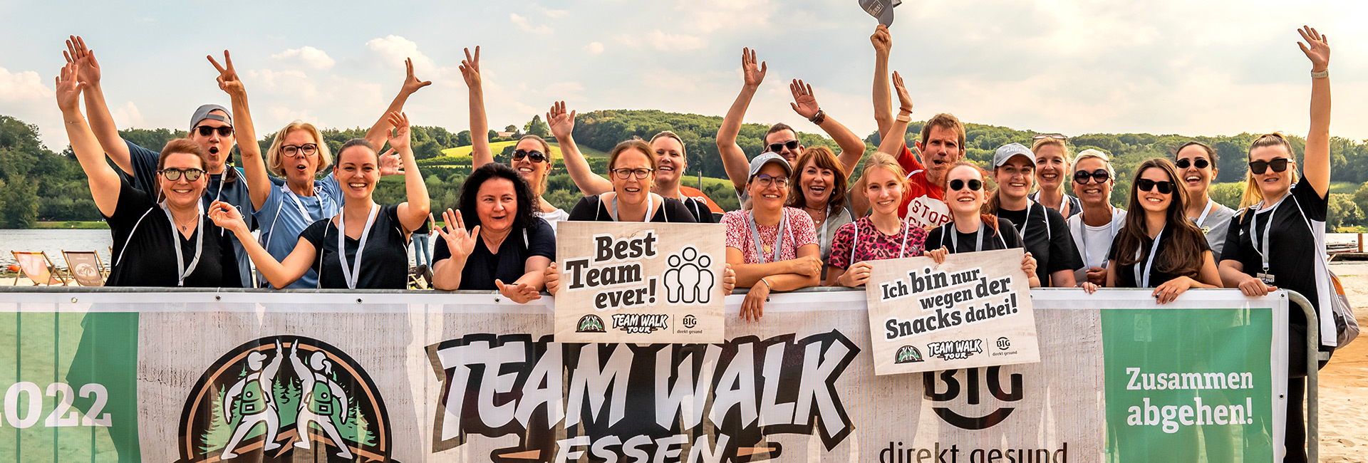 Ein Team jubelt hinter einem Banner mit der Aufschrift Team Walk Essen